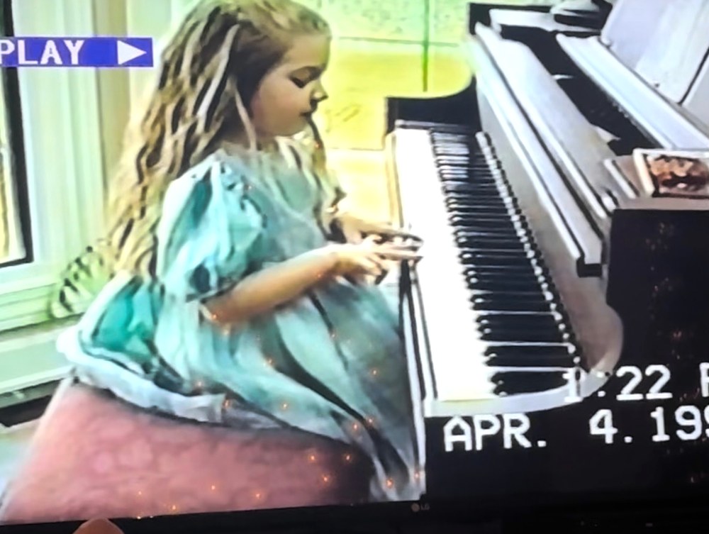 Madison playing piano as a young child
